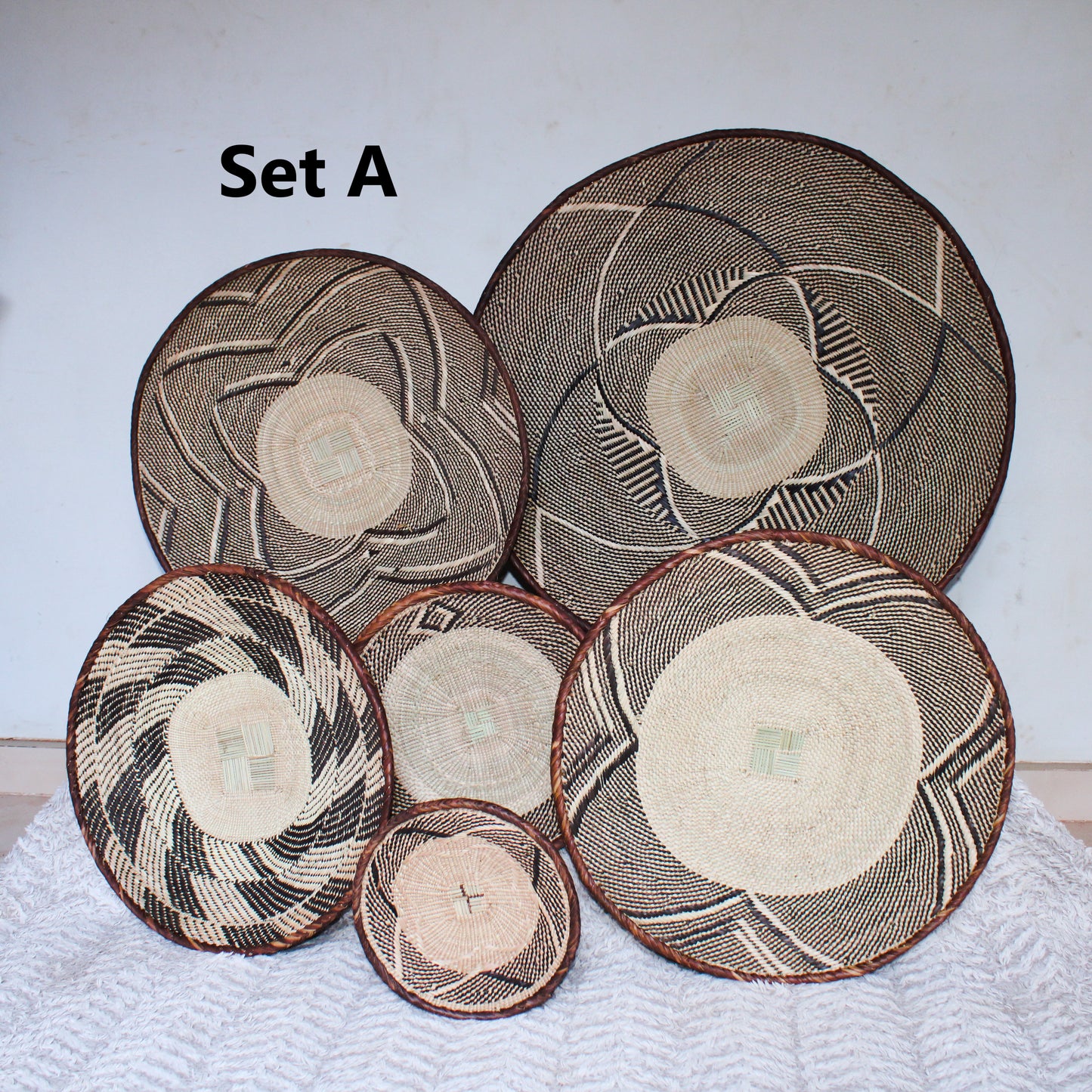 Set of woven baskets with geometric patterns on a white surface