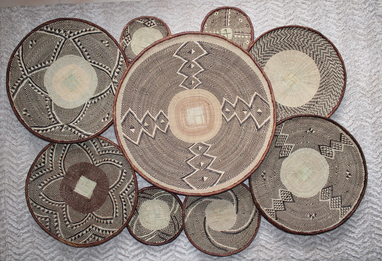 Set of woven baskets with geometric patterns on a textured surface