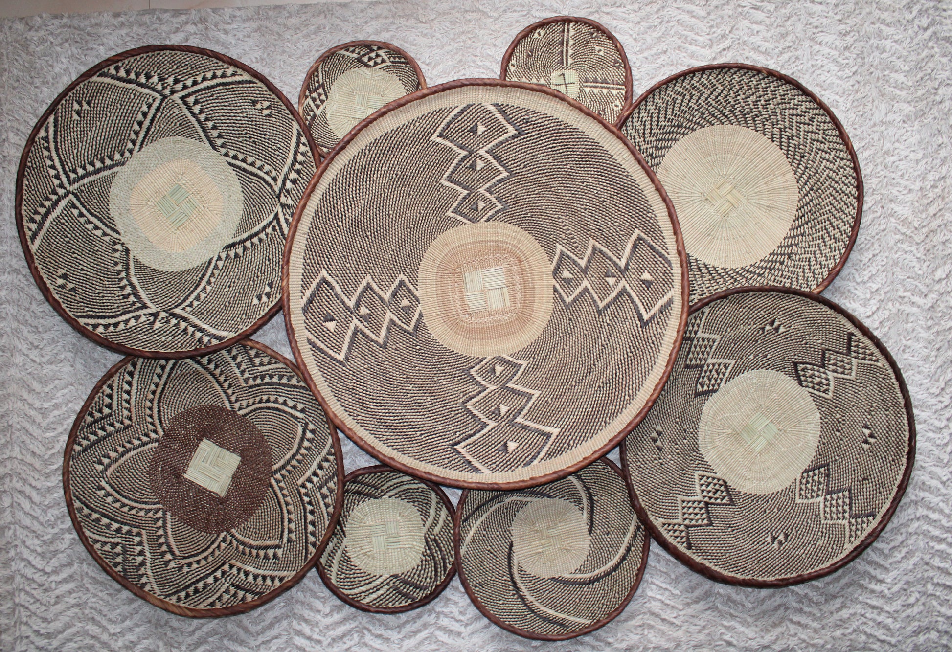Set of woven baskets with geometric patterns on a textured surface