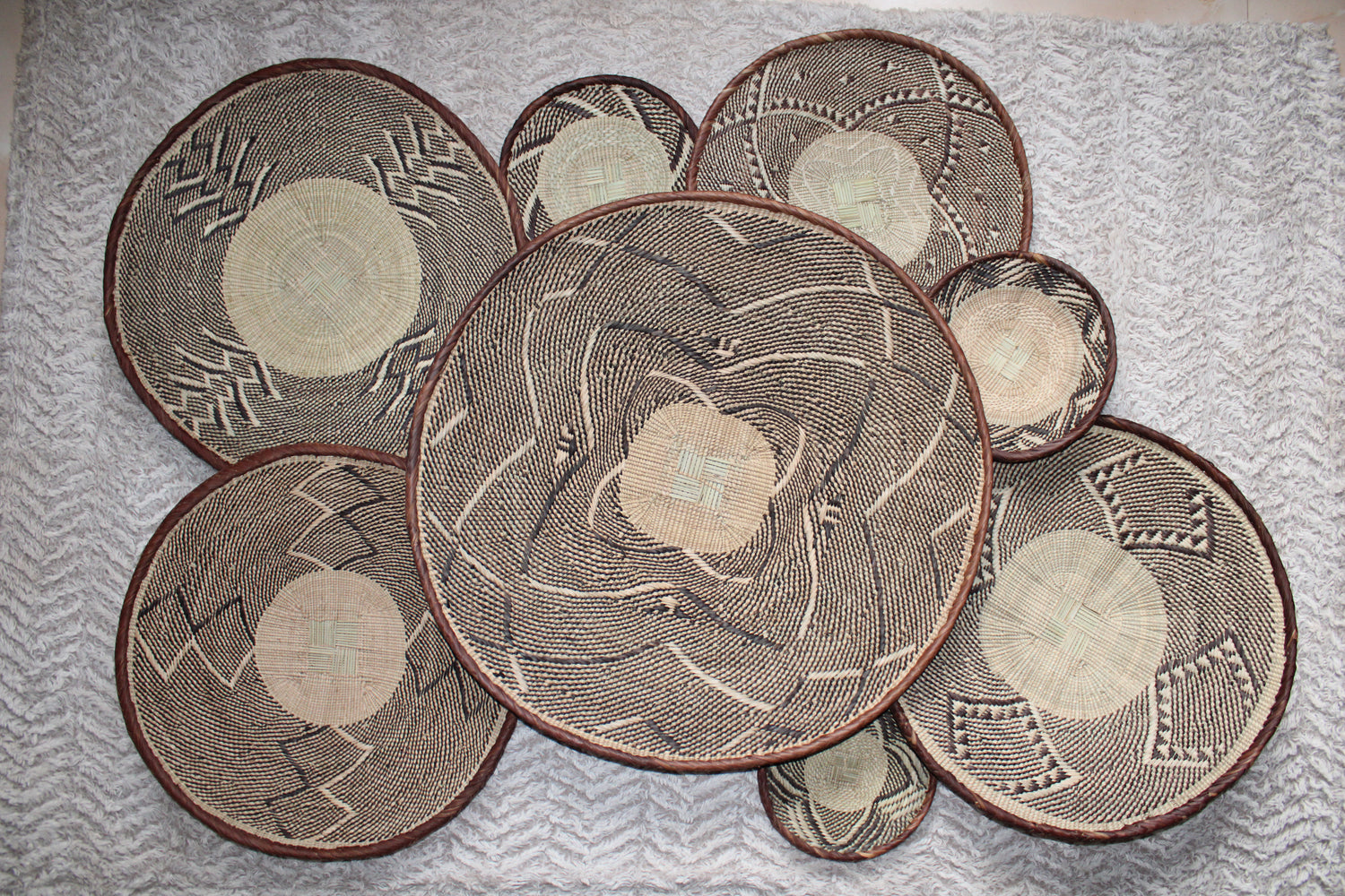 Set of woven placemats with geometric patterns on a textured surface