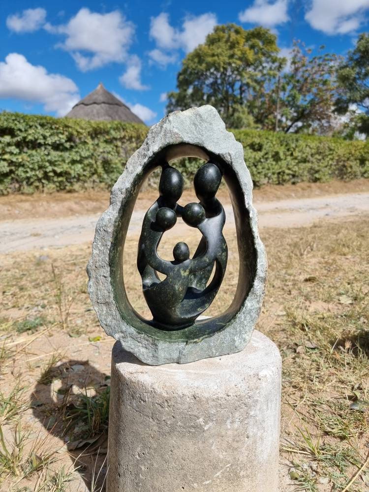 Abstract sculpture of a family in a stone setting with a natural background
